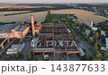 Steelworks scrap storage yard beside a steelmaking hall in a drone aerial view. Metal recycling, furnace feedstock storage and industrial infrastructure 143877633