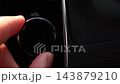 特寫鏡頭：用手轉動汽車導航系統的音量控制旋鈕。 143879210