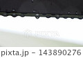 雨に濡れた金属製の縁に連なる水滴、雨の日 143890276