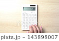 Hands using a calculator 143898007