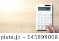 Hands using a calculator 143898008