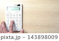 Hands using a calculator 143898009