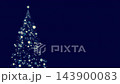 A video of a Christmas tree with glowing star and circular particle animation resembling shooting stars. The background is dark blue. Winter. 143900083