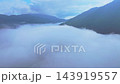 10月初旬朝に雲海から顔を出す箱根の山々を背景にドローンで雲海上を飛行する姿を捉えた4K空撮動画風景 143919557