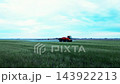 Self-propelled agricultural sprayer moves across a large green field, applying crop treatment with extended spray booms. Modern farming machinery used for crop protection and field management. 143922213