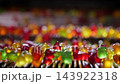 Colorful translucent jelly candies move along an industrial production line at a confectionery factory. Close-up of assorted gummy sweets during automated candy manufacturing. 143922318