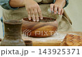 Close up shows baker adding seasoning into flour inside wooden bowl while preparing handmade bread . Traditional recipe and manual preparation recreate historic breadmaking process rooted in old 143925371