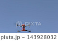 Drone hovers in clear blue sky, showcasing aerial technology and design features 143928032