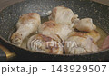 A close up of oil simmering in a speckled frying pan on a stove 143929507