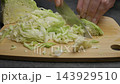 A hand is pouring oil into a frying pan 143929510