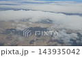Argentina - October 11, 2026: Aerial footage of scattered white clouds above the dry natural landscape of Patagonia, revealing patches of land through the cloud formations during flight. 143935042