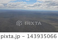 Argentina - October 11, 2026: View of extensive open terrain in Patagonia from a passenger airplane, showing the natural patterns of the land and scattered cloud formations during descent. 143935066