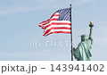 Statue of Liberty on Liberty Island, New York, USA. Flag and monument, patriotic symbol of democracy 143941402