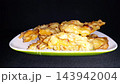 Crispy Golden Fried Snacks on White Plate with Dark Background 143942004