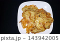 Indonesian Bakwan Fritters on White Plate with Copy Space. served on a white plate against a black background 143942005