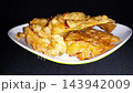 Close-up of Golden Crispy Indonesian Bakwan Fritters on a Plate, served on a white plate with a dark background.  143942009
