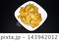 Crispy Indonesian Vegetable Fritters on White Plate with Copy Space, served on a white plate against a clean black background 143942012