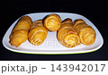 Delicious Indonesian Banana Molen Fried Pastries on White Plate, served on a white plate against a dark background 143942017