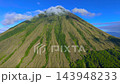 Aerial view of the steep grassy slopes and volcanic peak enveloped by clouds on Mount Inerie, Flores 143948233