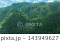 Aerial view of a small remote village surrounded by dense tropical rainforest mountains in Hawaii 143949627