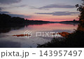 Pink sunset glow reflected in a wide calm river 143957497