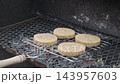 Herbed cheese patties grilling on a barbecue over hot coals 143957603