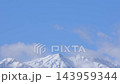 Snow-Covered Mountain Peaks with Flowing White Clouds Timelapse. 143959344