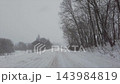 Walking along snowy road in snowfall 143984819