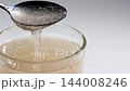 Textured psyllium husk gel forming in water inside a glass in studio 144008246