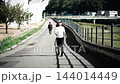 河川敷の遊歩道をウォーキングする女性 144014449