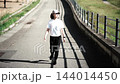 河川敷の遊歩道をウォーキングする女性 144014450