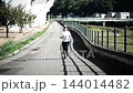河川敷の遊歩道をランニングする女性 144014482