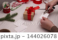 Handmade Christmas Gift Tags Being Prepared on a Cozy Home Craft Table 144026078